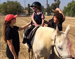 DPT students help a patient ride a horse