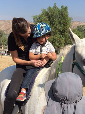 Patient and DPT Student riding a horse